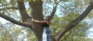 a young woman hugging a tree