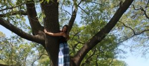 A young woman hugging a tree